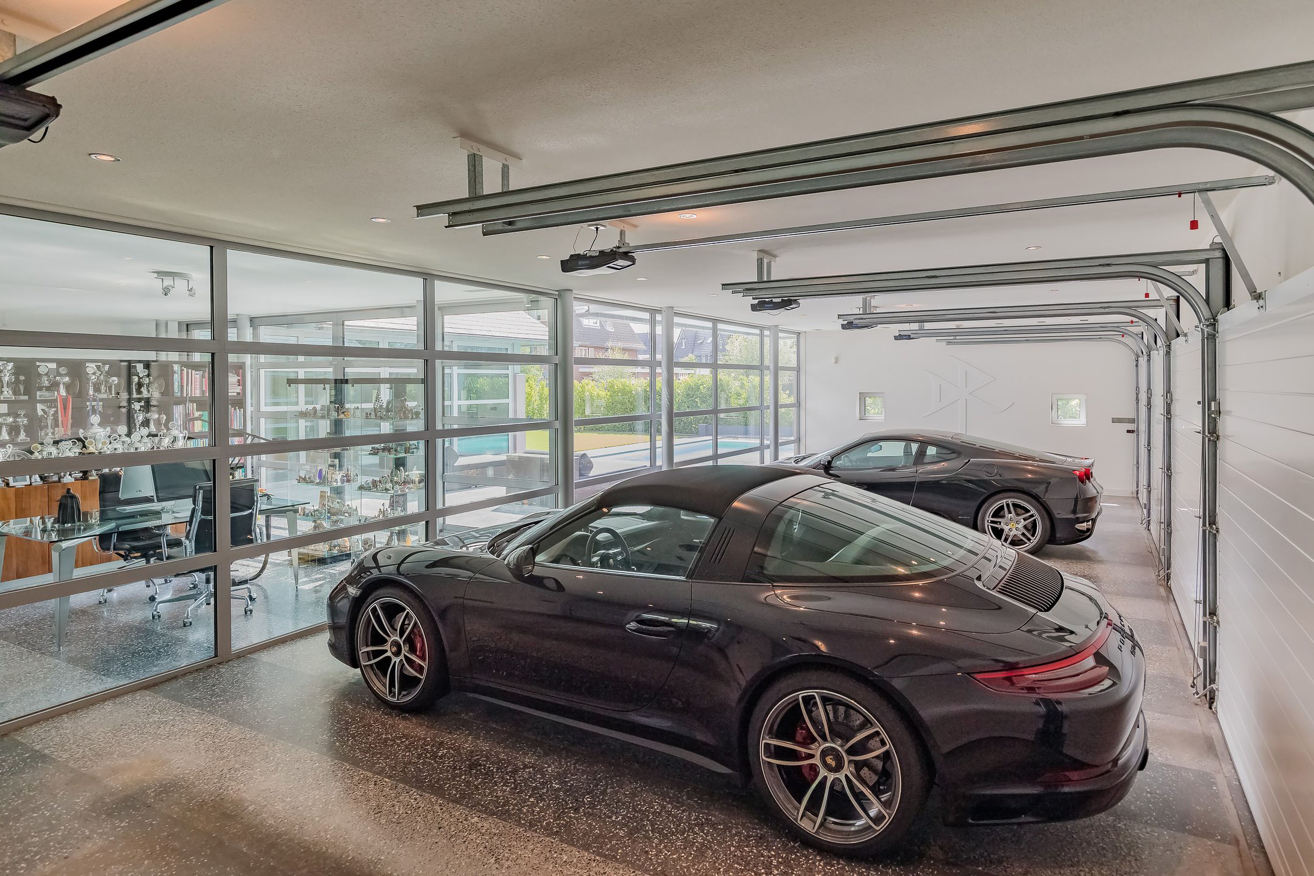 De garage van de villa in Noordwijk met daarin een Porsche en een Ferrair geparkeerd