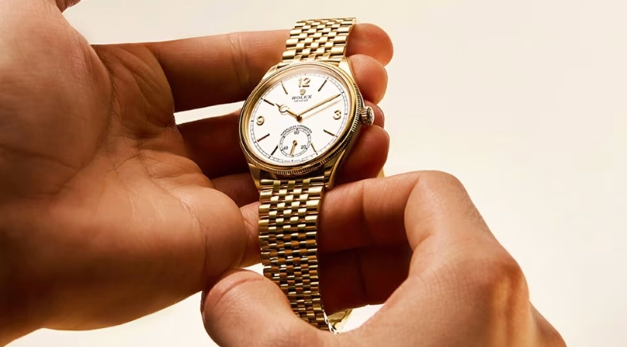 Een persoon die een Rolex 1908 vasthoudt