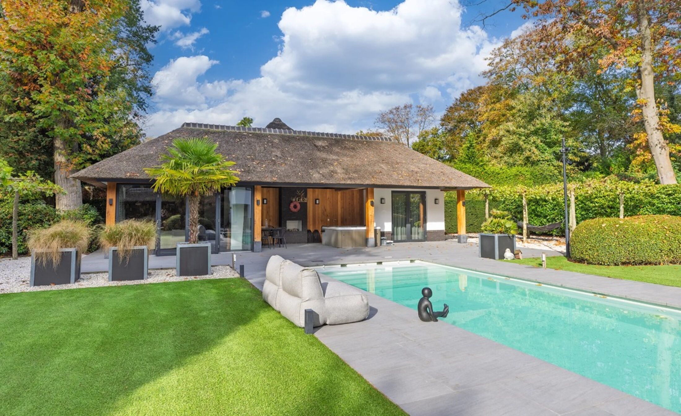 Het zwembad en het guesthouse die bij de villa in 't Gooi horen