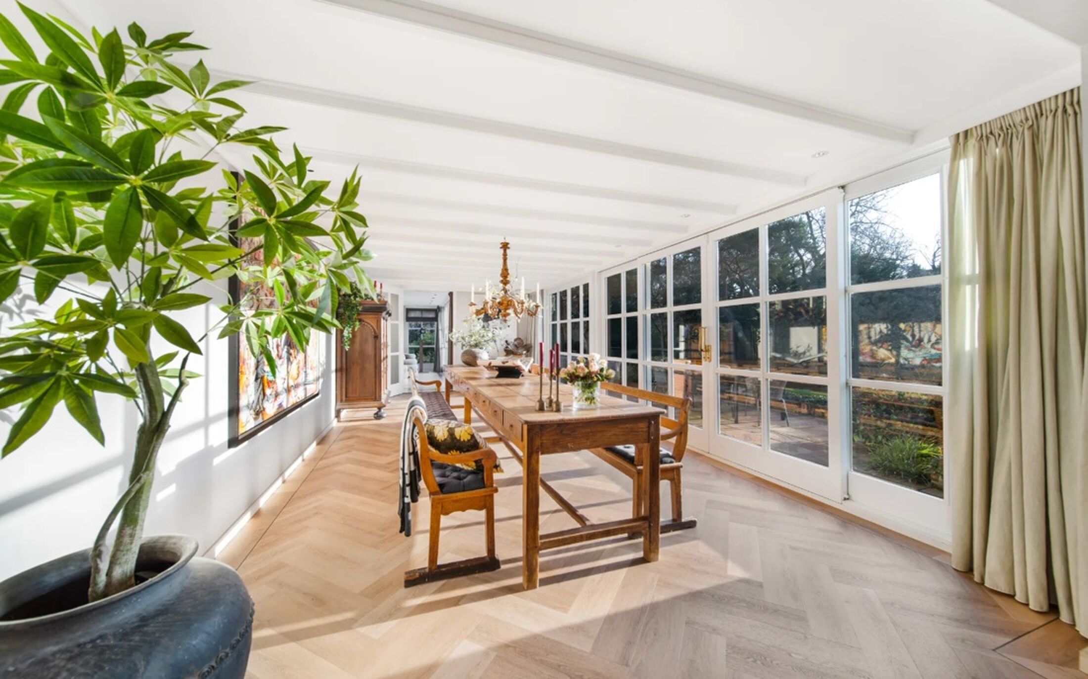 De meterslange eetkamer met uitzicht op de tuin