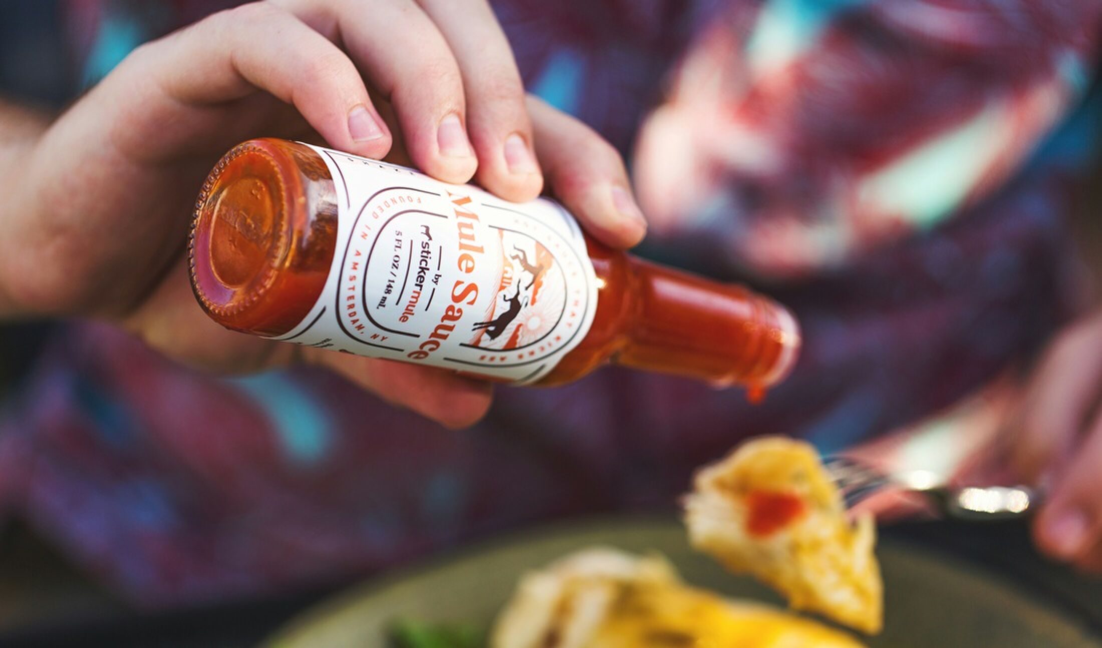 Iemand die pittige saus op eten doet