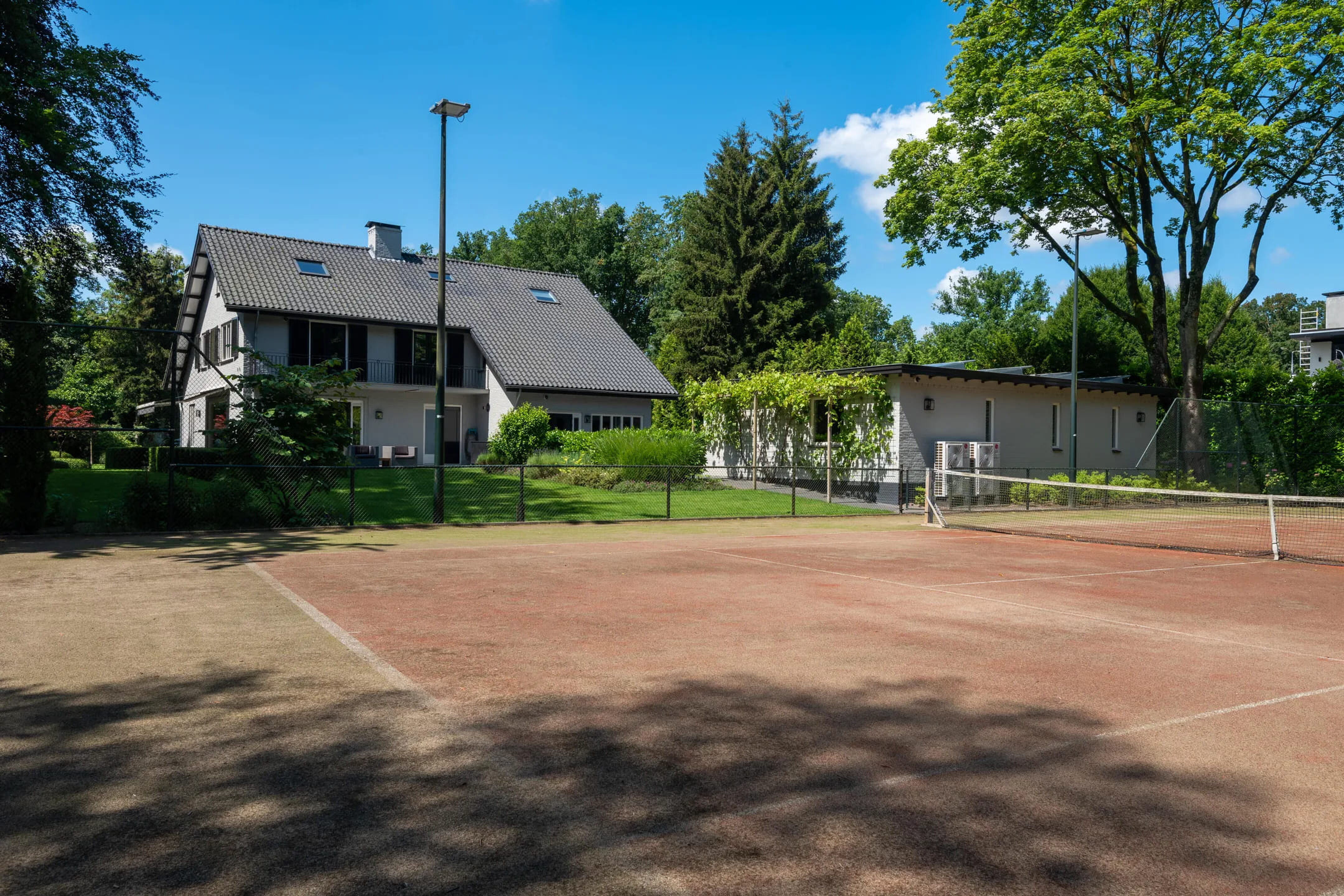 De tennisbaan bij de villa in Vught