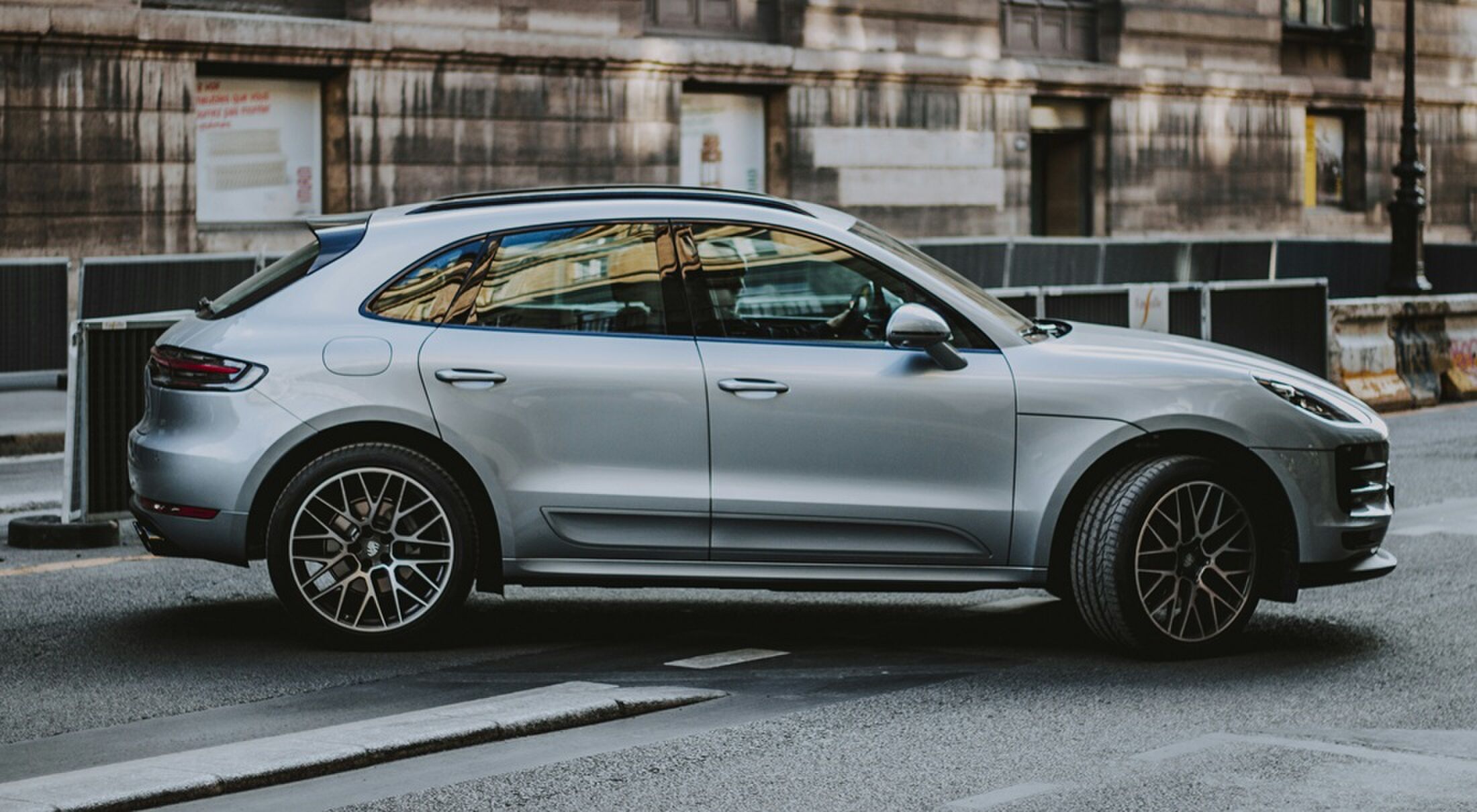 De zijkant van een rijdende Porsche Macan
