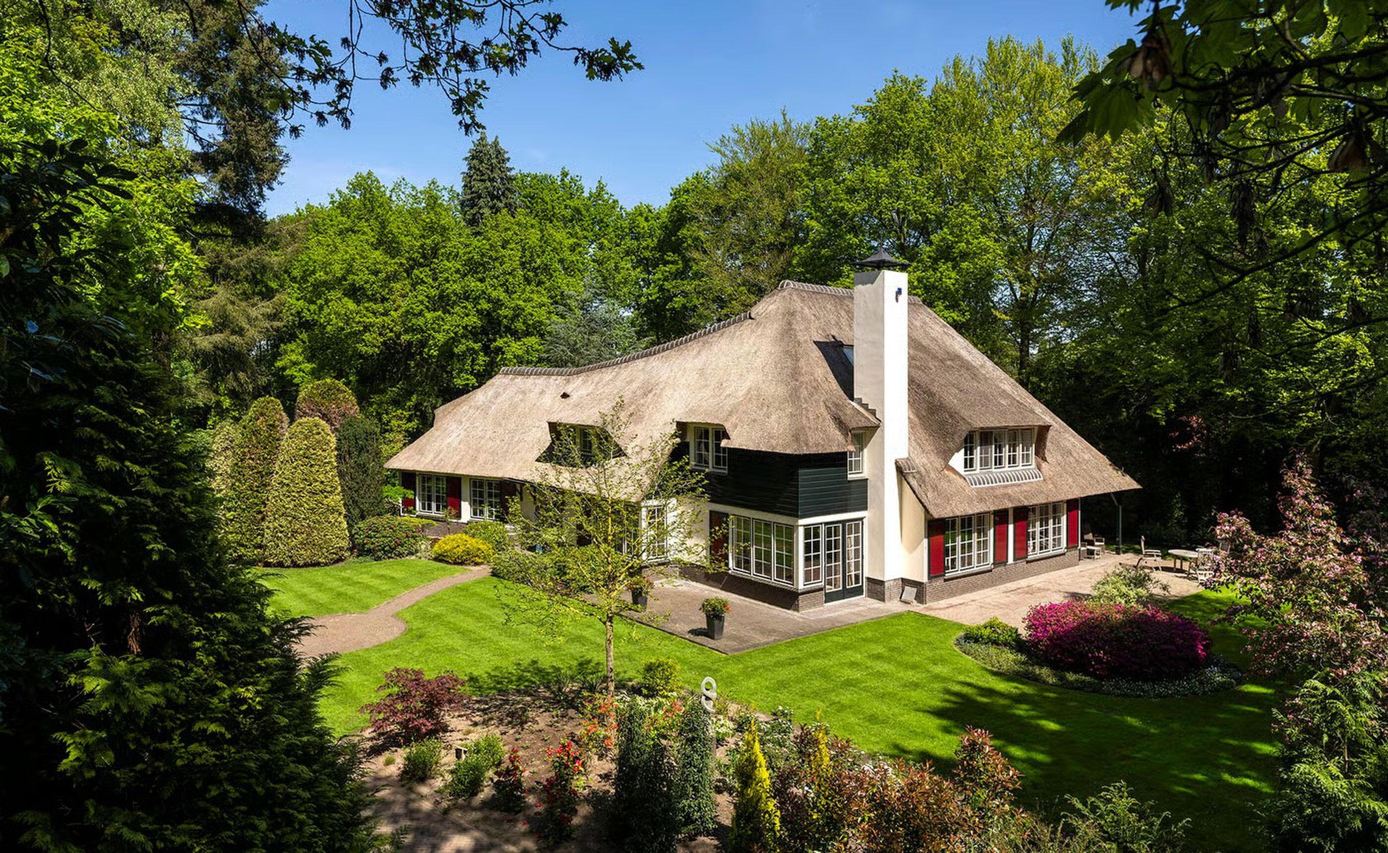 Mediagigant wil € 5.250.000 voor rietgedekte villa met parkachtige tuin en zwembad in het Gooi