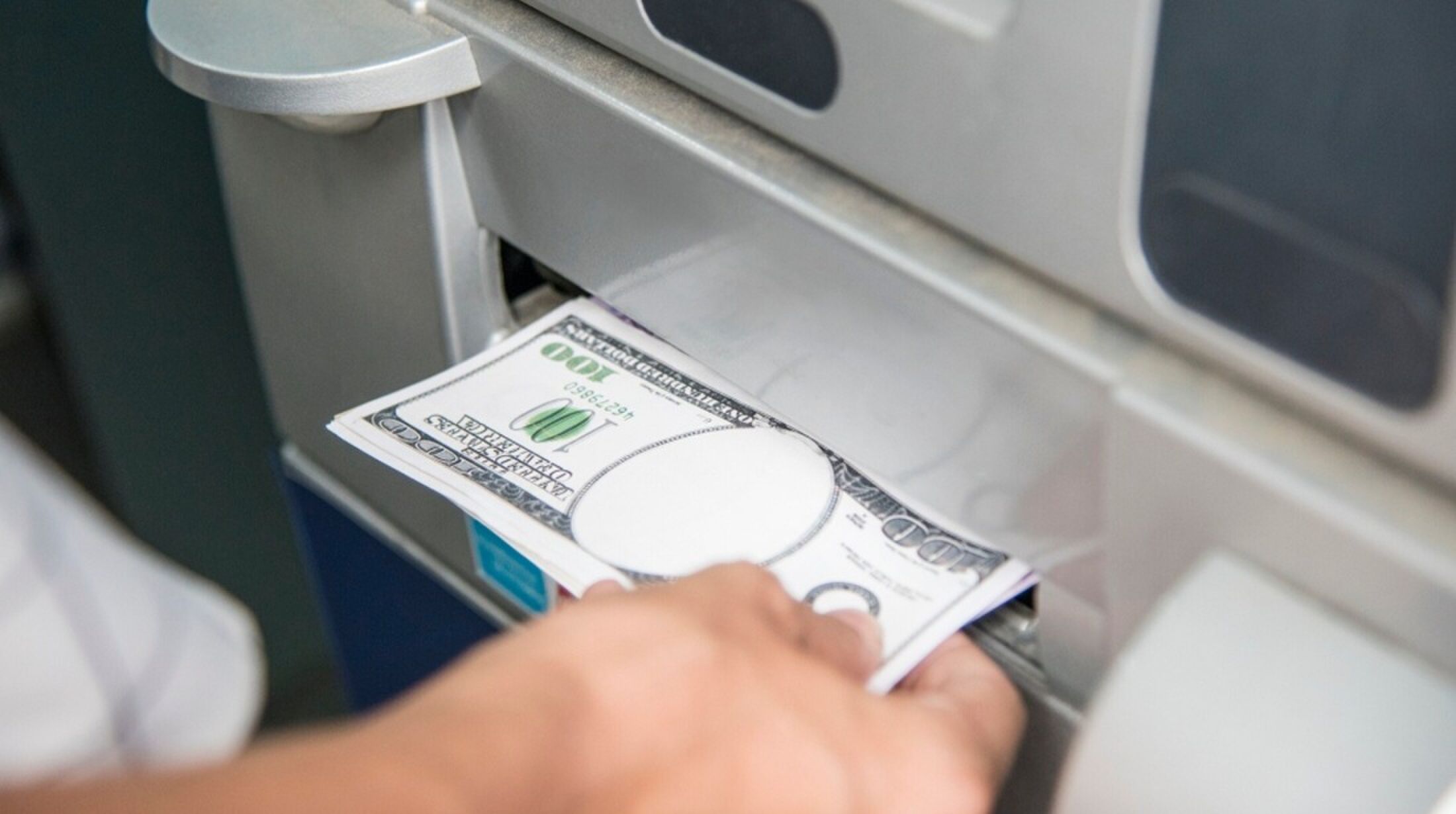 Persoon die geld uit een automaat haalt