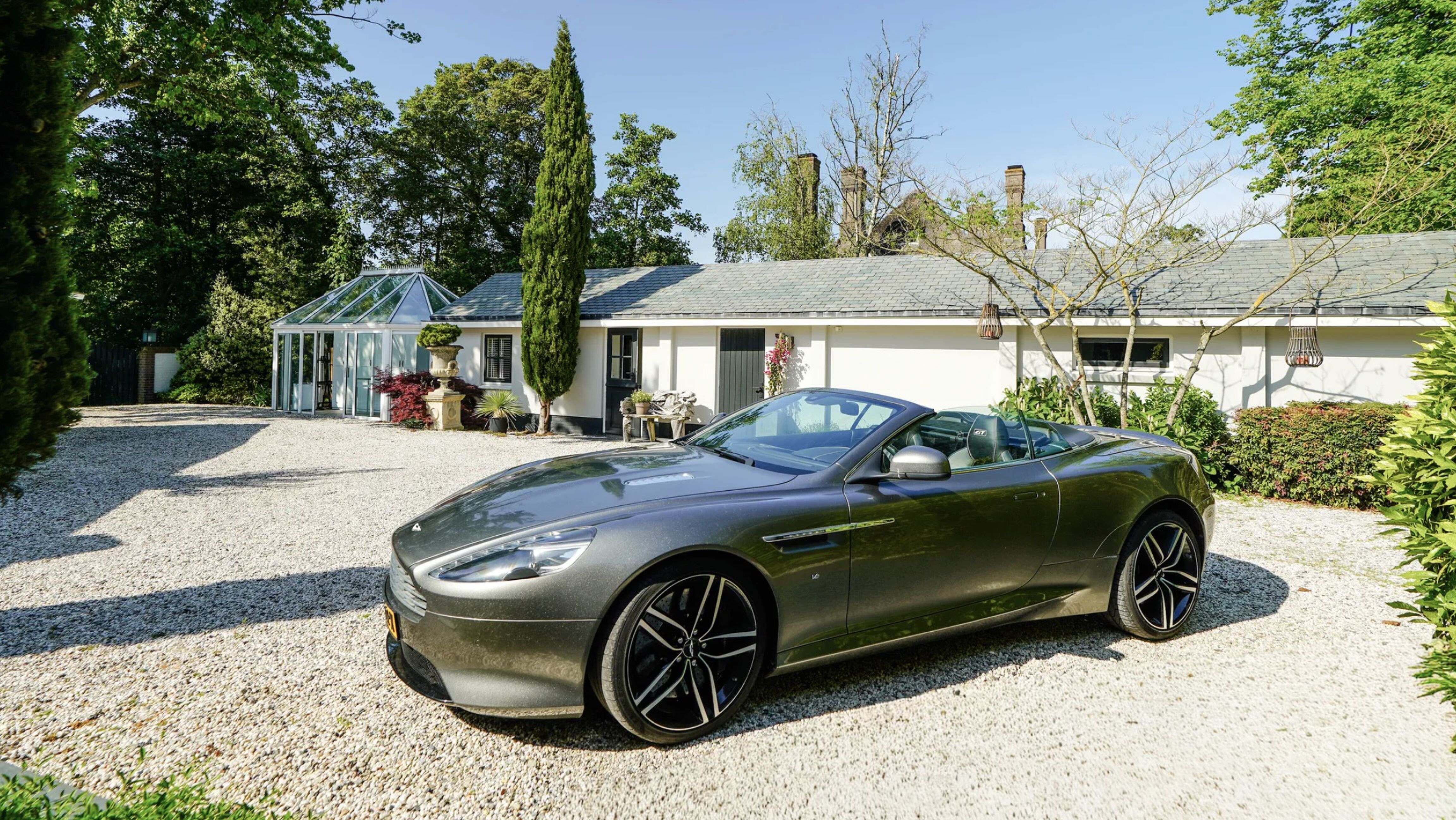 De oprit met aanwezige Aston Martin