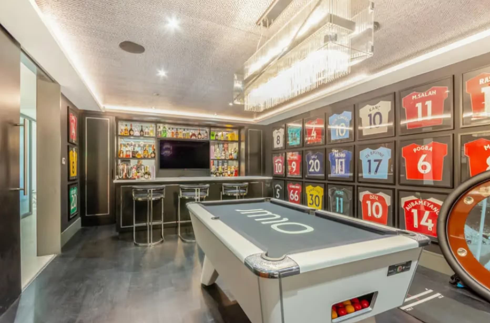 Een pooltafel en de collectie voetbalshirts in de woning van James Maddison