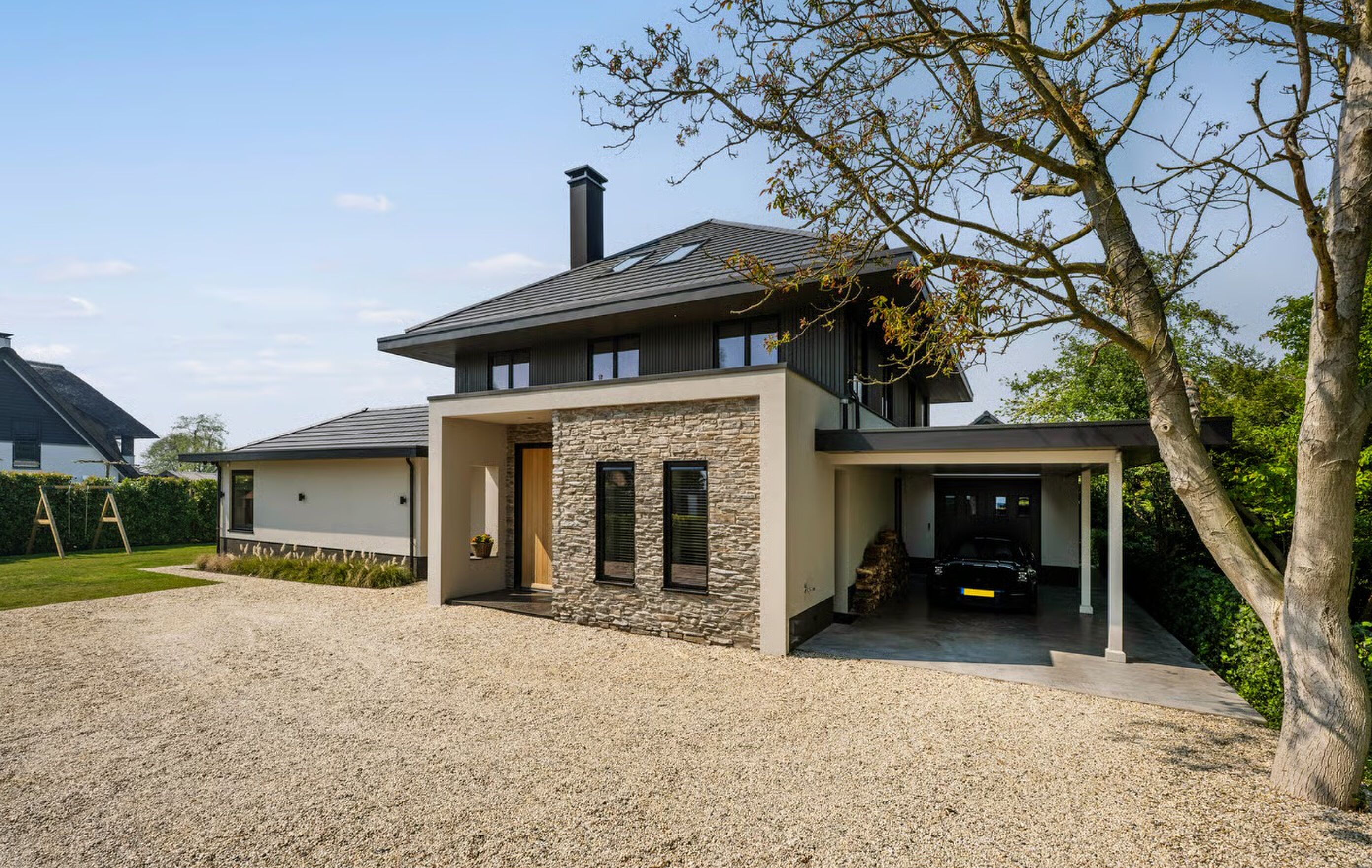 De voorzijde en de garage van de villa in Vinkeveen