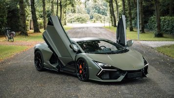 De Lamborghini Revuelto van Marktplaats met zijn vleugeldeuren open op een bospad