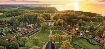 Het landgoed Weissenhaus in Schleswig-Holstein, met een zonsondergang op de achtergrond