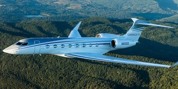 Een Gulfstream-priv&eacute;jet die door de lucht vliegt