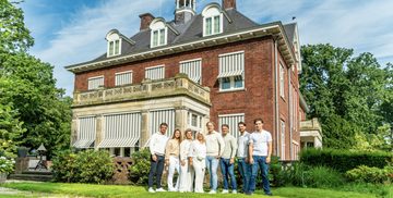 De familie Bogaart poseert voor hun villa