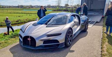 Een grijze Bugatti Tourbillon geparkeerd nabij de molens van Kinderdijk