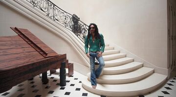 Lenny Kravitz staat op de wenteltrap in zijn woning in Parijs