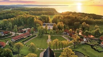 Het landgoed Weissenhaus in Schleswig-Holstein, met een zonsondergang op de achtergrond