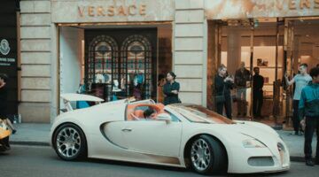 Een man in een dure auto die wellicht tot de jongste miljardairs ter wereld behoort