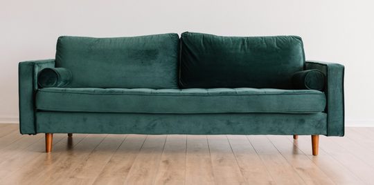 Een groene bank in een woonkamer