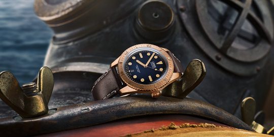Illustratie voor: Oris gedenkt het leven van Carl Brasher met dit prachtige bronzen horloge
