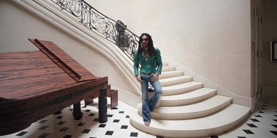 Lenny Kravitz staat op de wenteltrap in zijn woning in Parijs