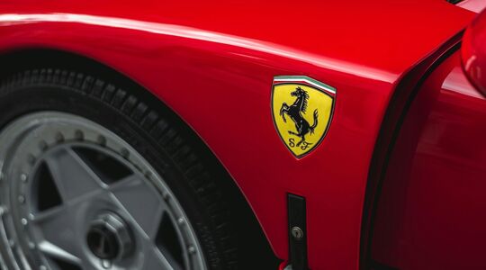 De zijkant van een Ferrari, waarbij er vooral op het logo is gefocust