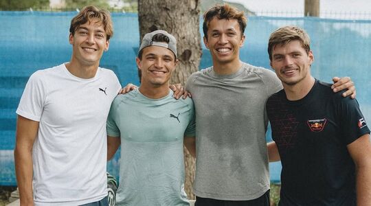 Formule 1-coureurs George Russell, Lando Norris, Alex Albon en Max Verstappen poseren voor een boom op een tropische bestemming