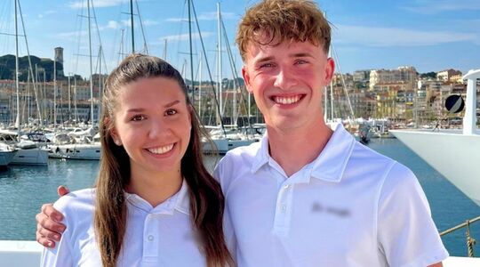 Het Britse stel Kyle Forster en Phoebe Robinson terwijl ze poseren op het superjacht waarop ze werken