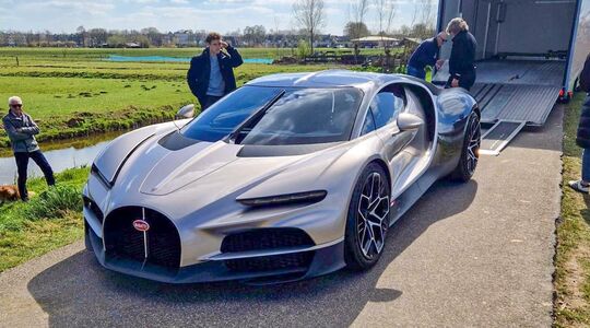 Een grijze Bugatti Tourbillon geparkeerd nabij de molens van Kinderdijk