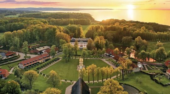 Het landgoed Weissenhaus in Schleswig-Holstein, met een zonsondergang op de achtergrond