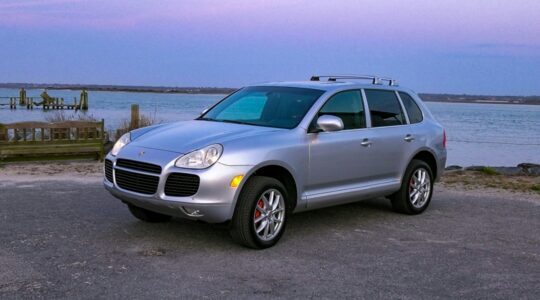 Een zilvergrijze Porsche Cayenne
